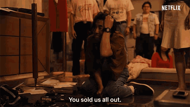 a man kneeling on the floor with the words you sold us all out behind him
