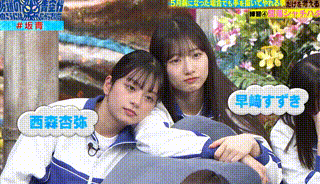 a couple of girls are sitting next to each other on a pillow with chinese writing on them .