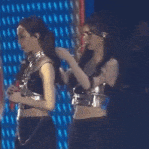two women are standing next to each other on a stage in front of a blue background .