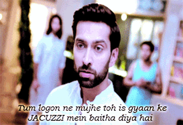 a man with a beard is standing in front of a sign that says tum logon ne mujhse toh