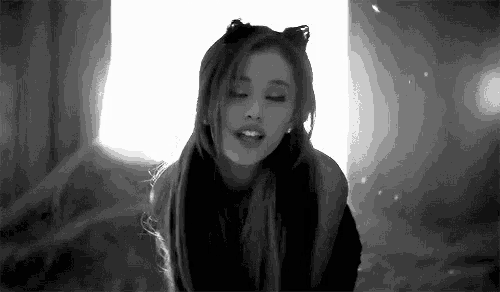 a black and white photo of ariana grande with cat ears on her head .
