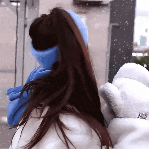 a woman wearing a blue scarf and a white coat