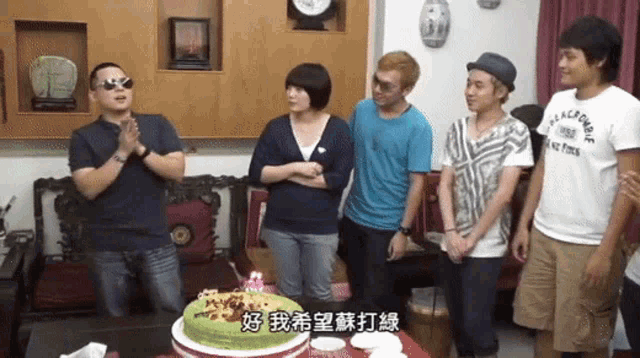 a group of people are gathered around a birthday cake with chinese writing on it