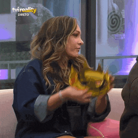 a woman is holding a crown in front of a tvreality logo