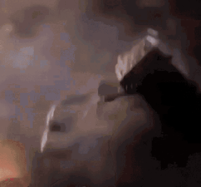 a close up of a person holding a gun in a dark room