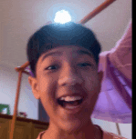 a young boy is making a funny face in front of a light .