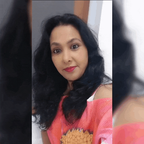 a woman with long black hair is wearing a pink sweater