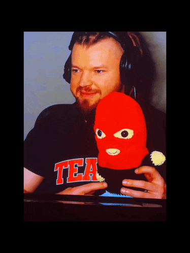 a man wearing headphones and a black shirt that says tea