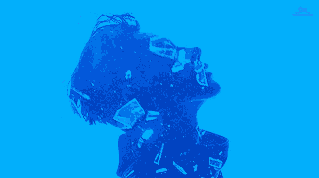 a man 's face is projected on a blue background with sm entertainment written on the bottom