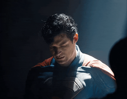 a man in a superman costume is looking down