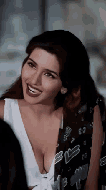 a woman with a very plunging neckline is smiling and wearing a jacket with the letter b on it