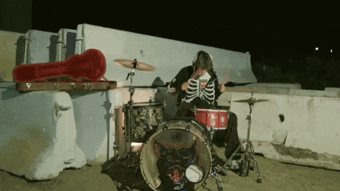 a man playing drums with a cat on the drum