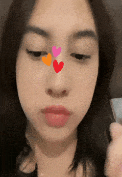 a close up of a woman 's face with three hearts on it