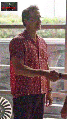 a man wearing a red shirt shakes hands with another man