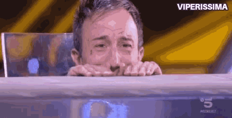 a man is crying in front of a screen that says viperissima on the bottom