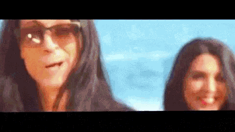 a man and a woman wearing sunglasses are standing next to each other .