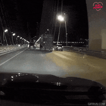 a car is driving down a highway at night with the words girl power written on the bottom