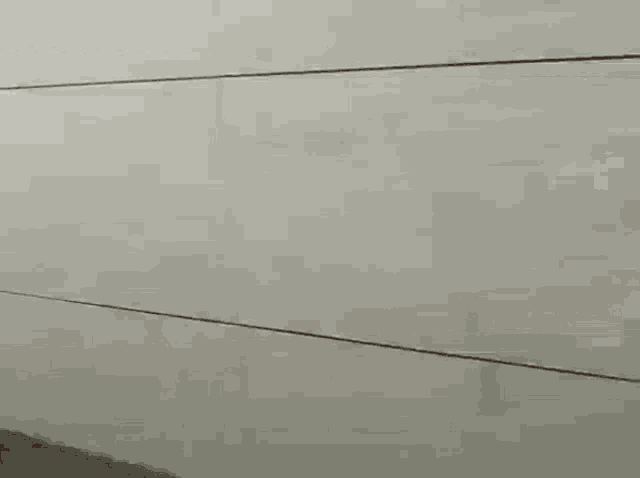 a close up of a white wall with a reflection of a person in it .