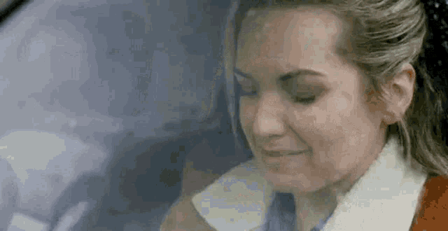a woman is sitting in a car and smiling .