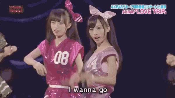 two girls wearing pink shirts with the number 08 on them are singing into microphones