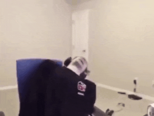a person is laying on a chair in a room with a bottle of soda on their head .