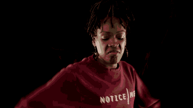 a woman wearing a red sweatshirt that says " noti " on it