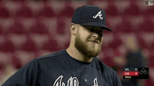 a man with a beard wearing a baseball cap with the letter a on it