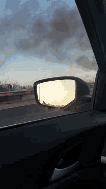 a car is driving down a highway with smoke coming out of the side mirror