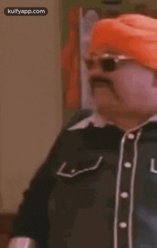 a man with a mustache and sunglasses is wearing a turban .