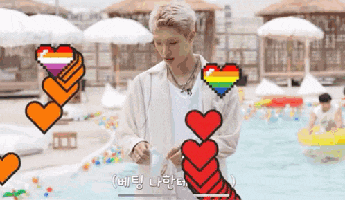 a man is standing in front of a pool with a rainbow heart in the background