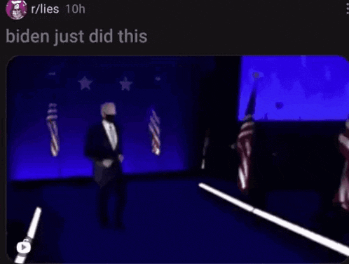a blurry picture of a man in a suit dancing on a stage with flags in the background .