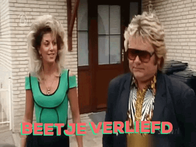 a man and a woman are standing in front of a brick building with the words beetje verliefd on the bottom right