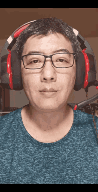 a man wearing glasses and headphones with a blue shirt
