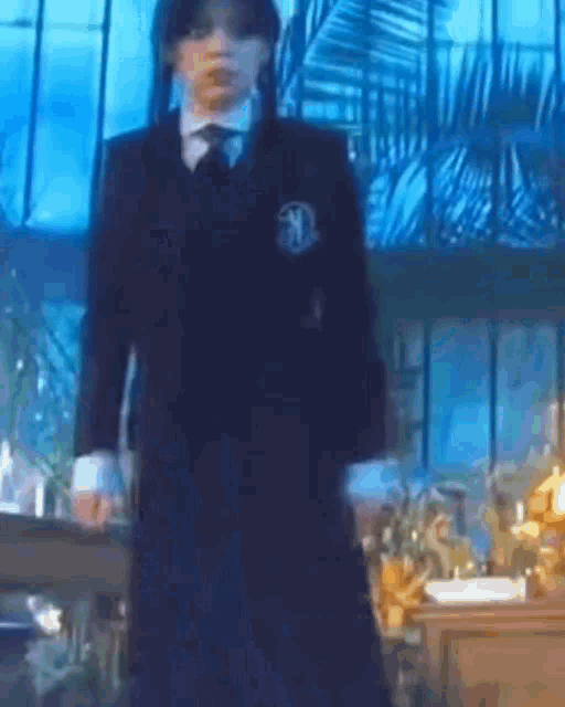 a man in a suit and tie is standing in a room with a lot of windows .