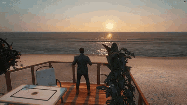 a man stands on a balcony overlooking the ocean with the sun setting in the background