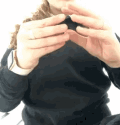 a woman in a black sweater is taking a picture of herself