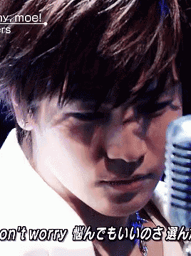 a man singing into a microphone with the words " don 't worry " written below him