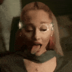 a woman is sticking her tongue out and wearing a mask on her face .