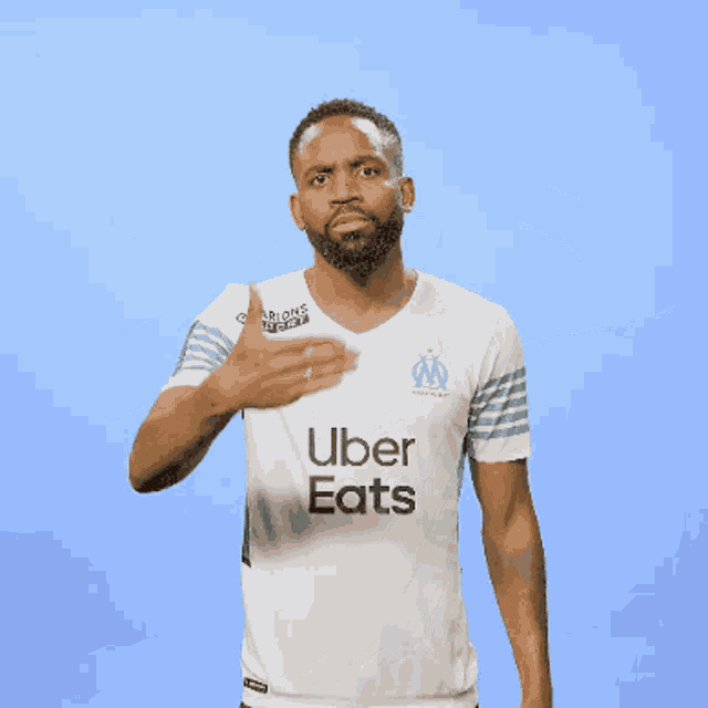 a man wearing an uber eats shirt covers his mouth with his hand