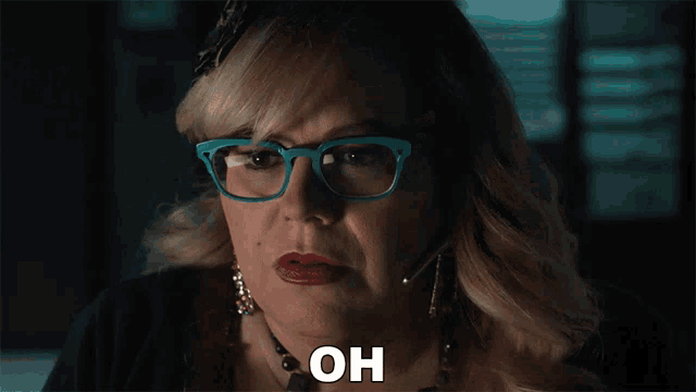 a woman wearing glasses and a necklace says oh on her face