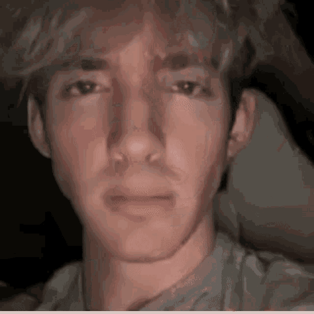 a close up of a young man 's face with a tear coming out of his eye .
