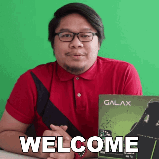 a man in a red shirt is holding a box that says galax on it