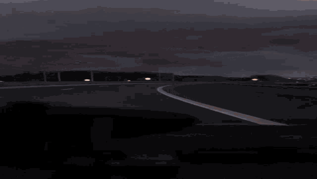 a car is driving down a highway at night with a blurred background