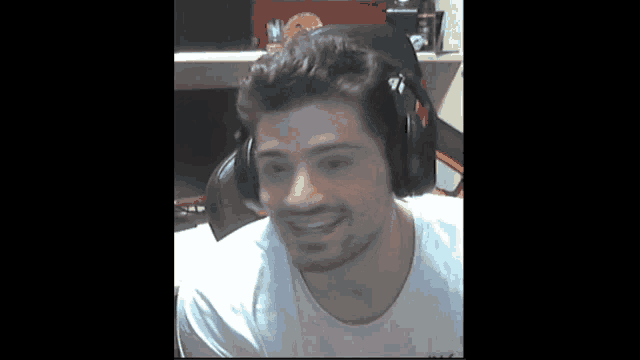 a man wearing headphones and a white shirt looks at the camera