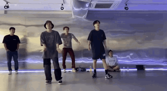 a group of men are dancing in a dance studio .