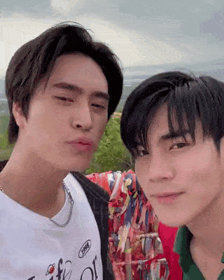 two young men are standing next to each other and making faces .