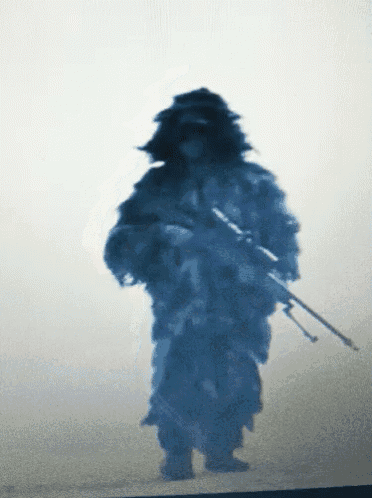 a silhouette of a soldier holding a rifle in a foggy area