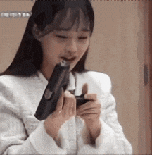 a woman in a white jacket is holding a gun