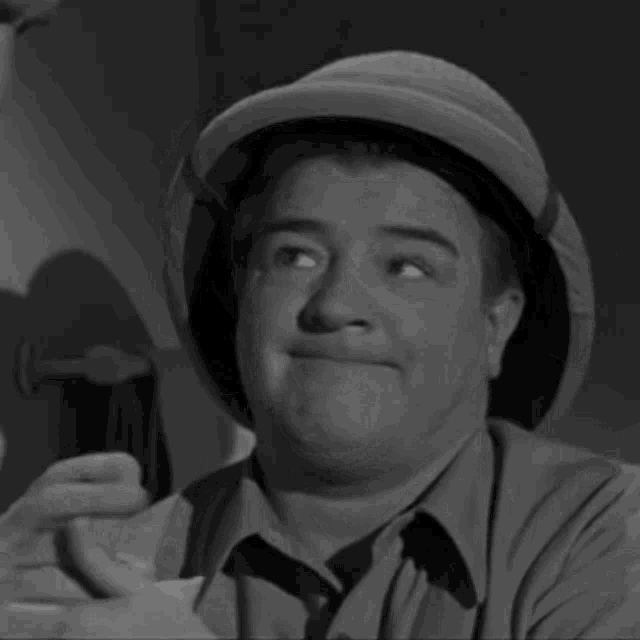 a man in a safari hat is making a funny face