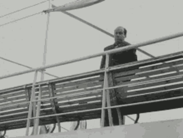 a man is standing on a wooden bench on a boat .